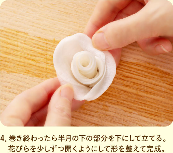4．巻き終わったら半月の下の部分を下にして立てる。花びらを少しずつ開くようにして形を整えて完成。